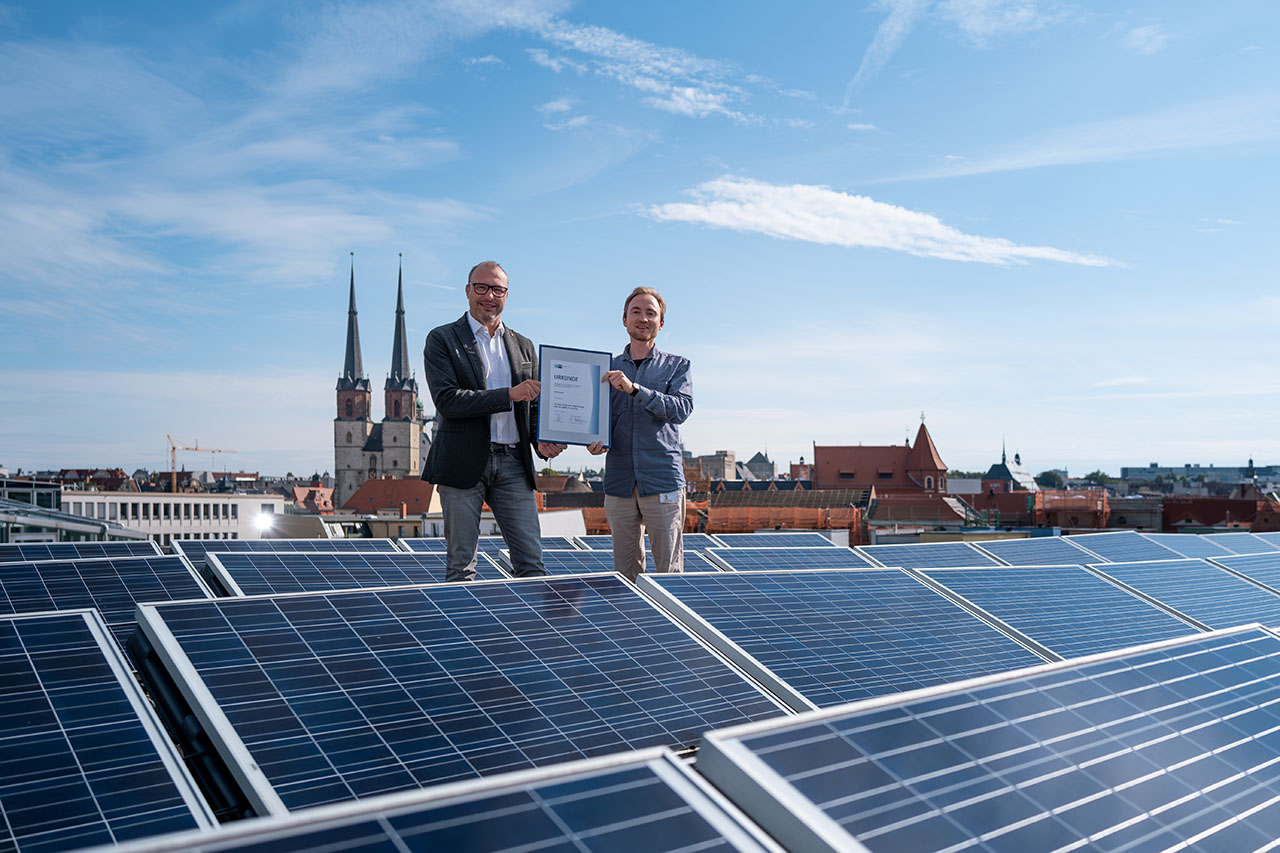 25 Jahre EMAS Übergabe der Urkunde für 25 Jahre erfolgreiche Registrierung nach der EMAS-Verordnung mit Blick über die Dächer von Halle (Saale)